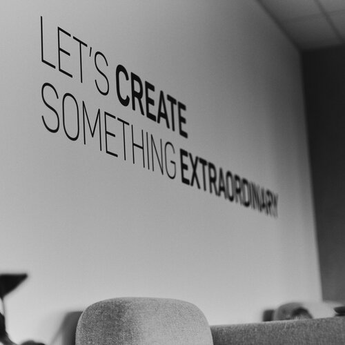 Motivationsspruch Let's Create Something Extraordinary an der Wand des Büros der Mindspace GmbH
